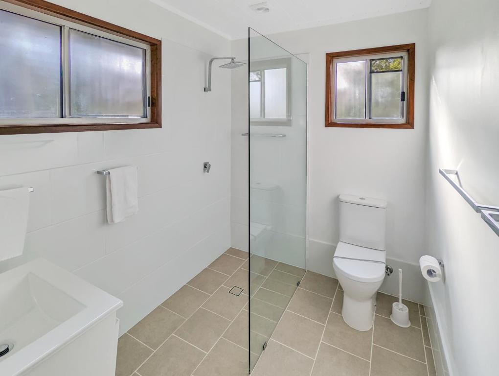 un bagno con wc e doccia in vetro di Gumnut Glen Cabins a Yeppoon