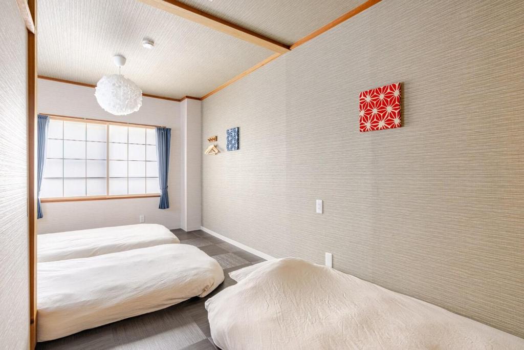 名古屋市にあるDomus OZONEのベッド2台と窓のある寝室