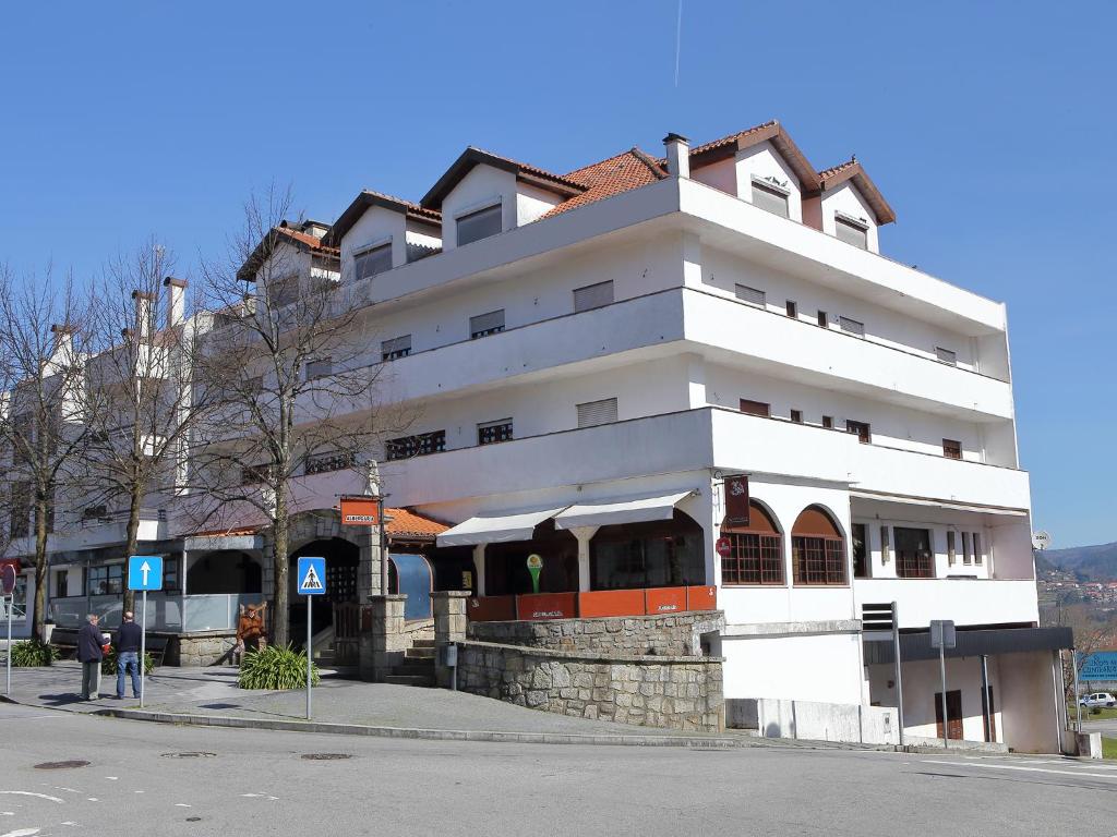 un edificio blanco en la esquina de una calle en Residencial Albergaria, en Paredes de Coura