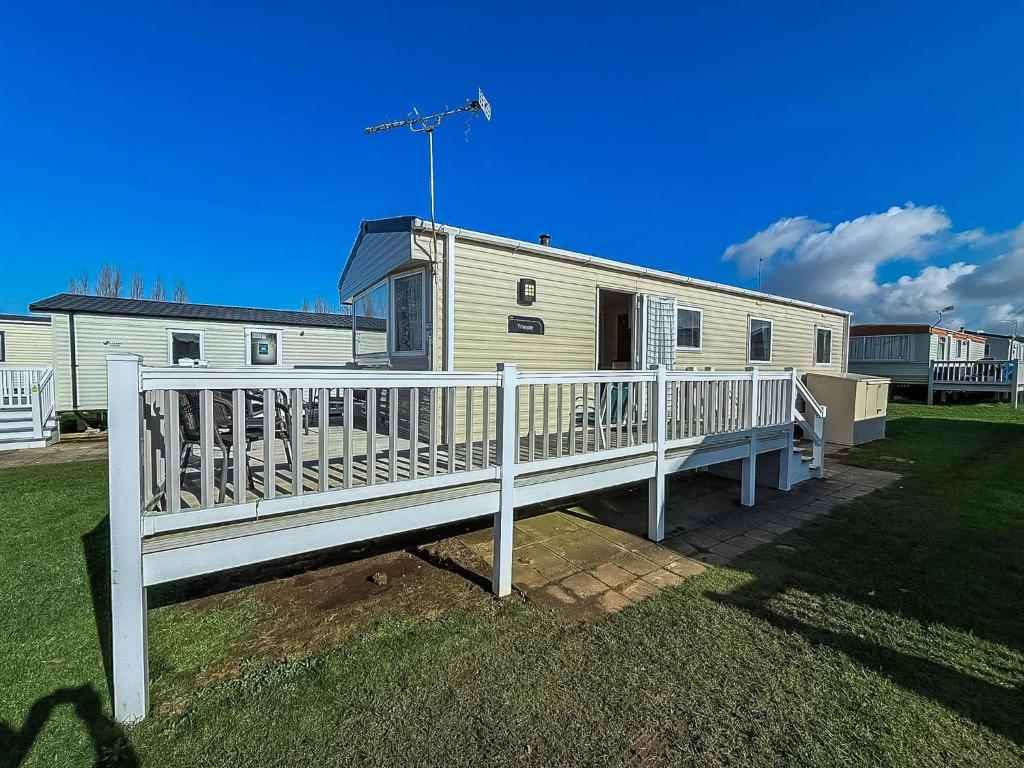 Casa móvil con porche y valla blanca en Beautiful Caravan With Decking At Manor Park, Hunstanton Ref 23098T, en Hunstanton