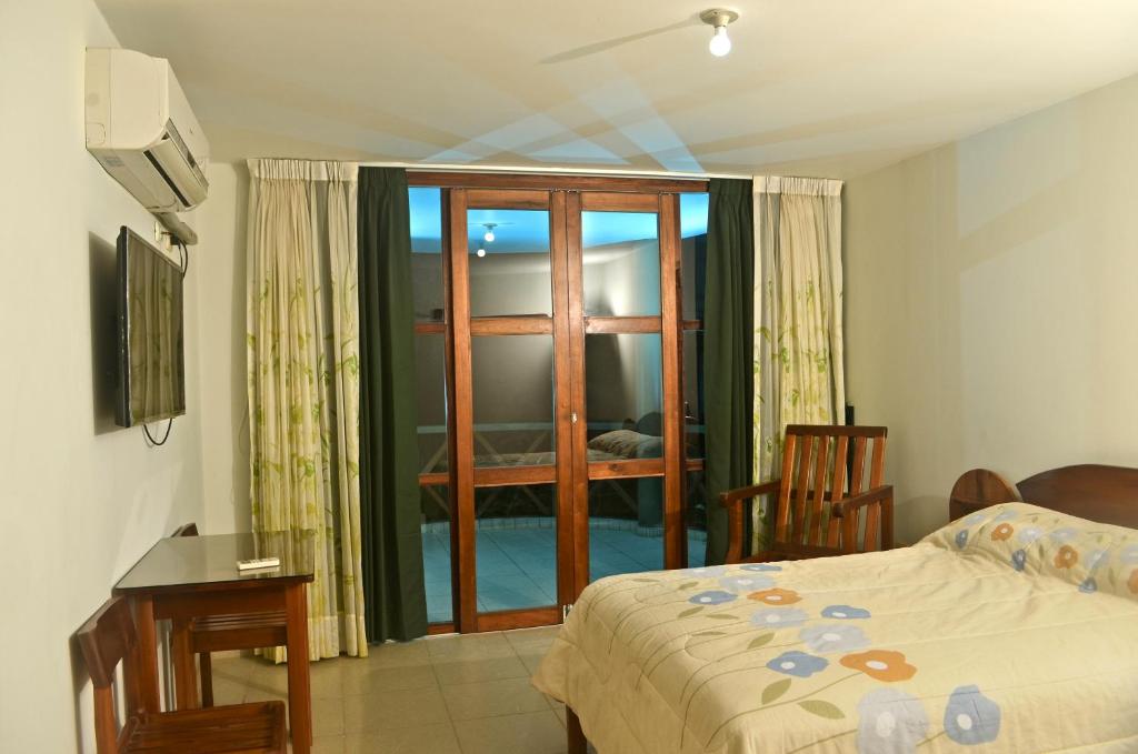 a bedroom with a bed and a sliding glass door at Ecolodge El Palmero in Mazamari