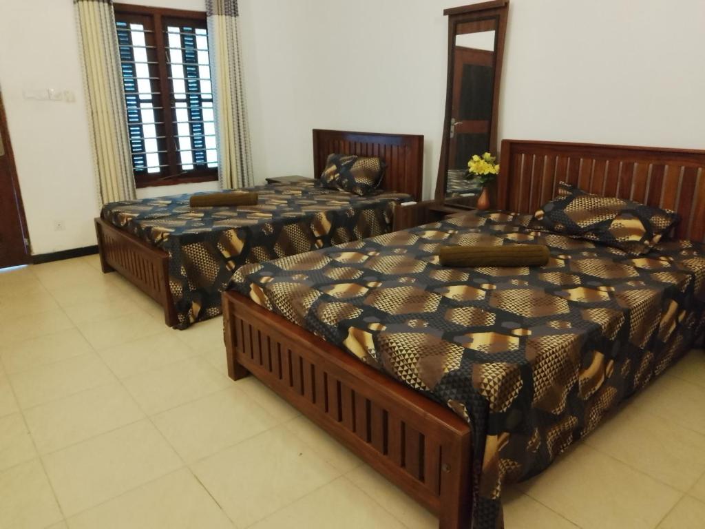 a room with three beds in a room at Banana Leaf Garden in Weligama