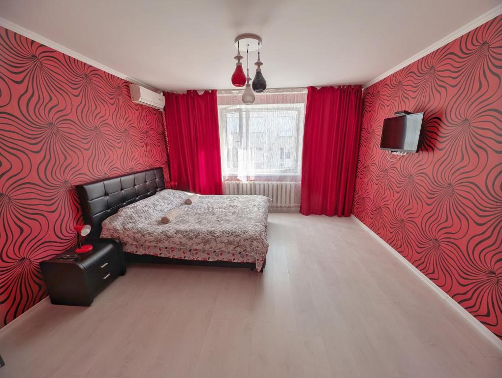 Stylish apartment في كيشيناو: غرفة نوم بجدران حمراء وسرير ونافذة