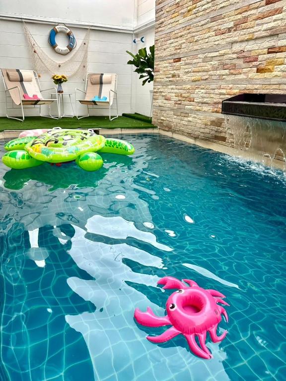 a swimming pool with two inflatables in the water at Phirom2 pool villa pattaya in Jomtien Beach