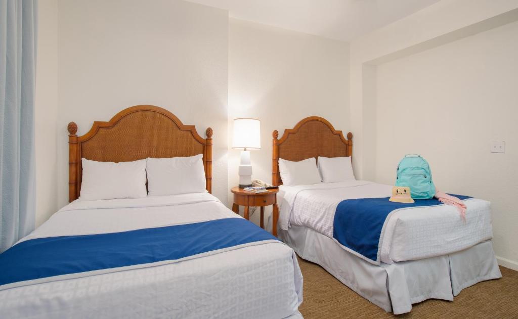 two beds in a hotel room with a toy on the bed at Lake Buena Vista Resort Village and Spa, Near Disney in Orlando