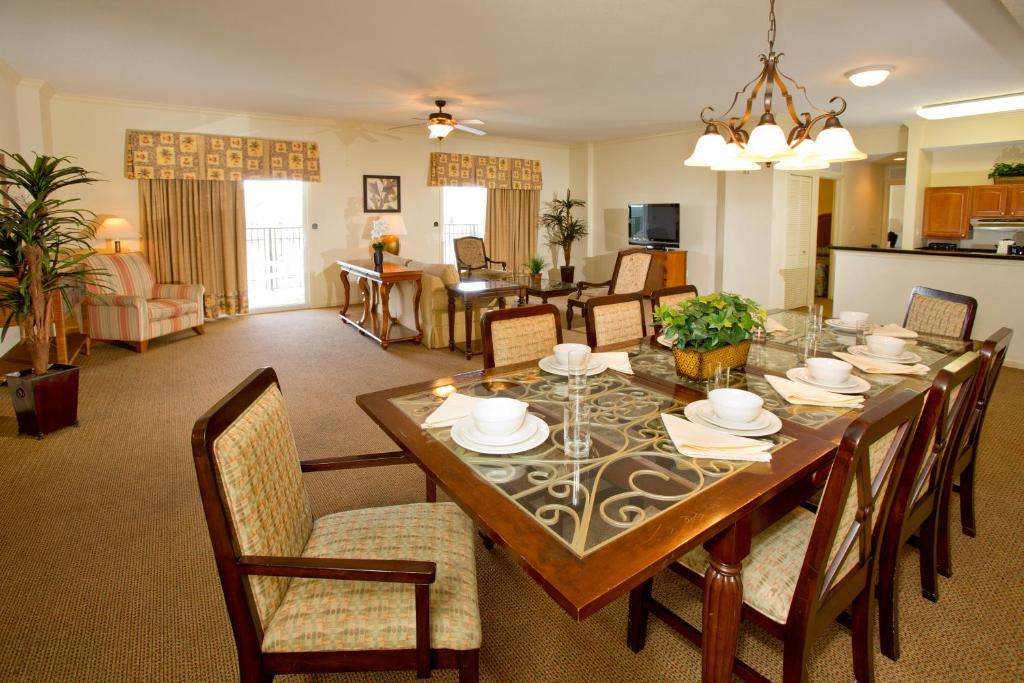 a dining room and living room with a table and chairs at Lake Buena Vista Resort Village and Spa, Near Disney in Orlando
