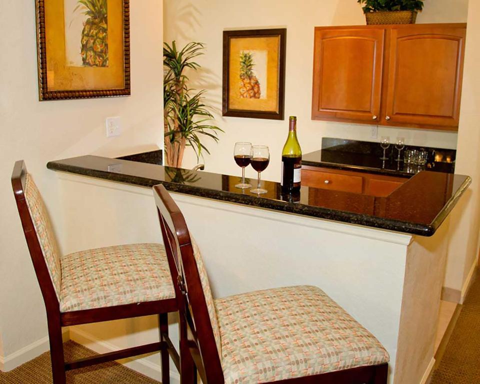 a kitchen with a bar with two glasses of wine at Lake Buena Vista Resort Village and Spa, Near Disney in Orlando