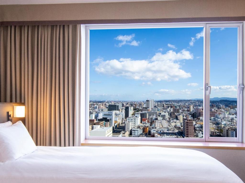 大分市にあるホテル日航大分 オアシスタワーのベッドルーム1室(市街の景色を望む大きな窓付)