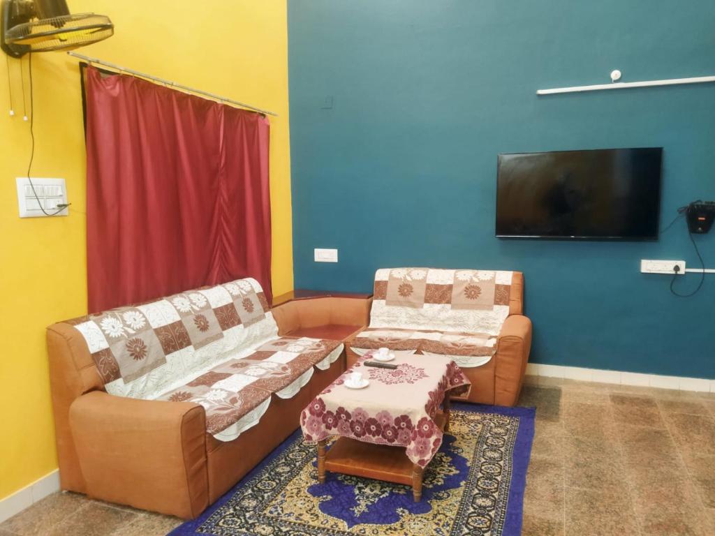 a living room with two couches and a tv at Private Villa With Swimming Pool at White Town in Puducherry