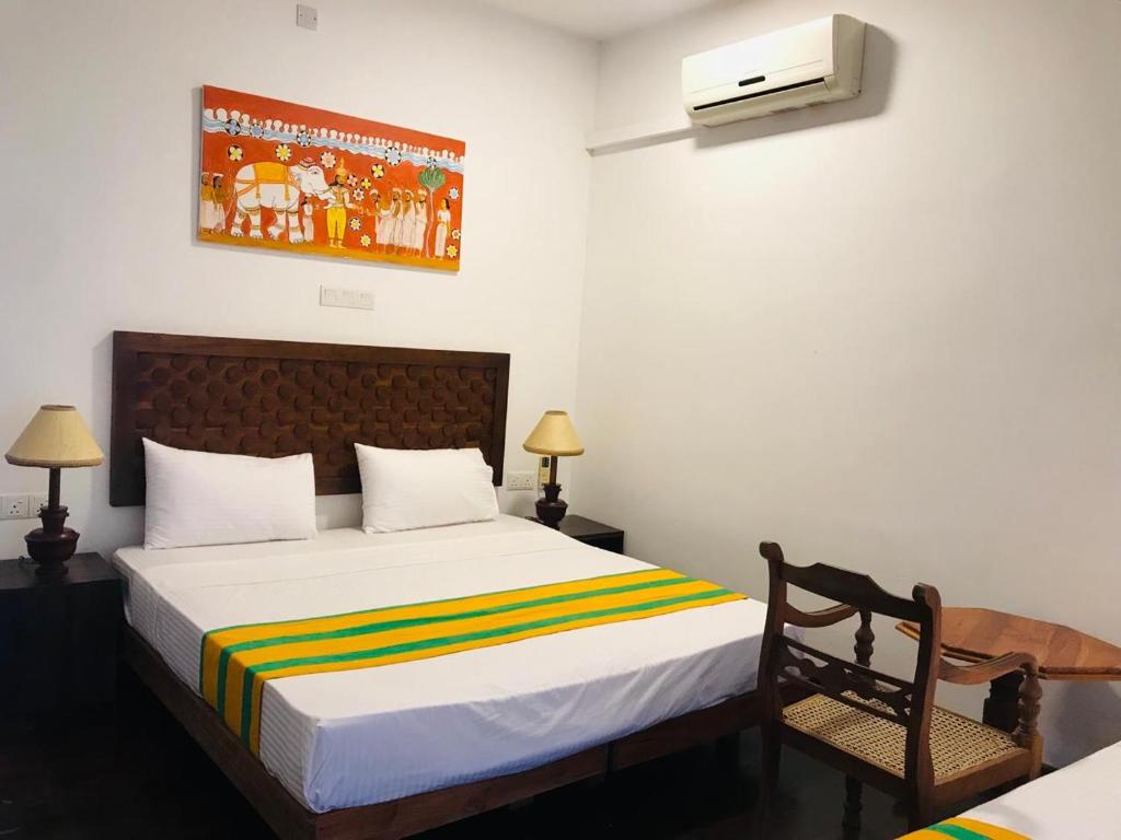 a bedroom with a bed and a chair in it at My Home Resort Yala Safari in Tissamaharama