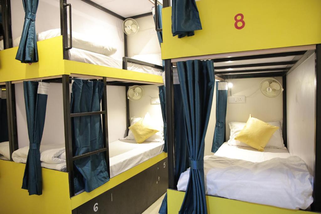 a couple of bunk beds in a yellow room at Bed Station AC Dormitory in Varanasi