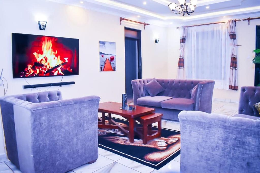 a living room with couches and a fire in the wall at 5 bedroom bungalow in Kisumu City in Kisumu