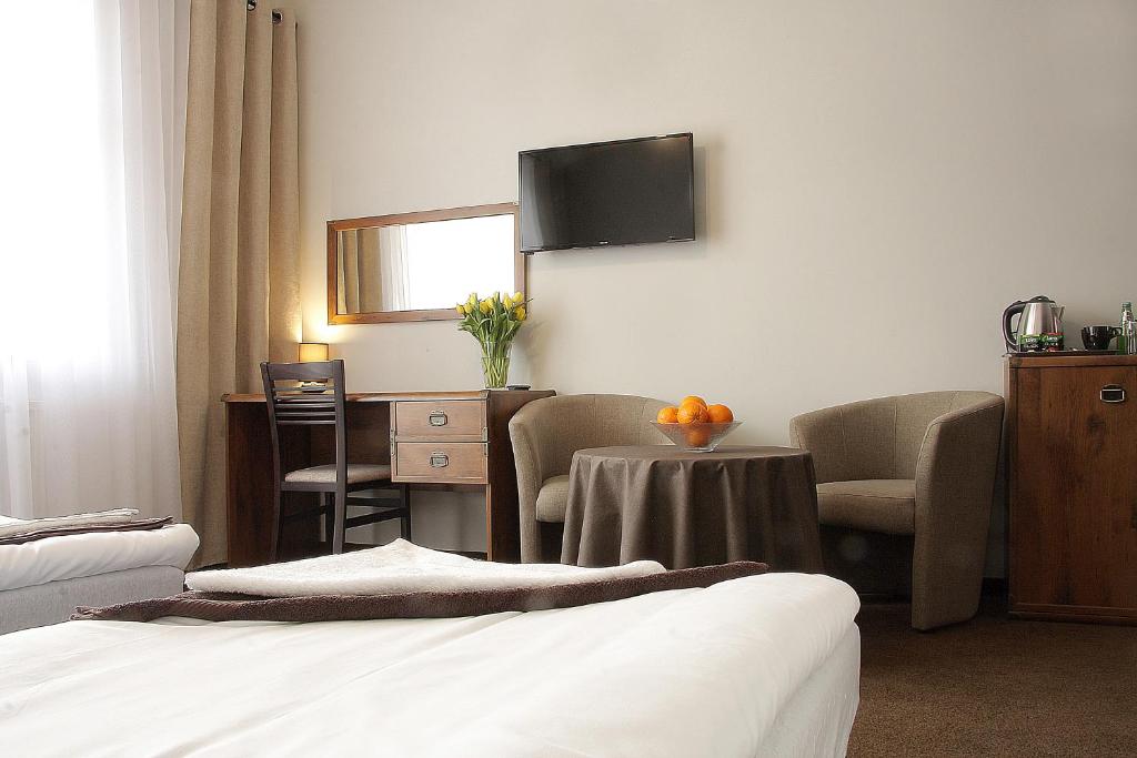 ein Hotelzimmer mit einem Bett, einem Tisch und Stühlen in der Unterkunft Rest- Pokoje z Łazienkami in Gdynia