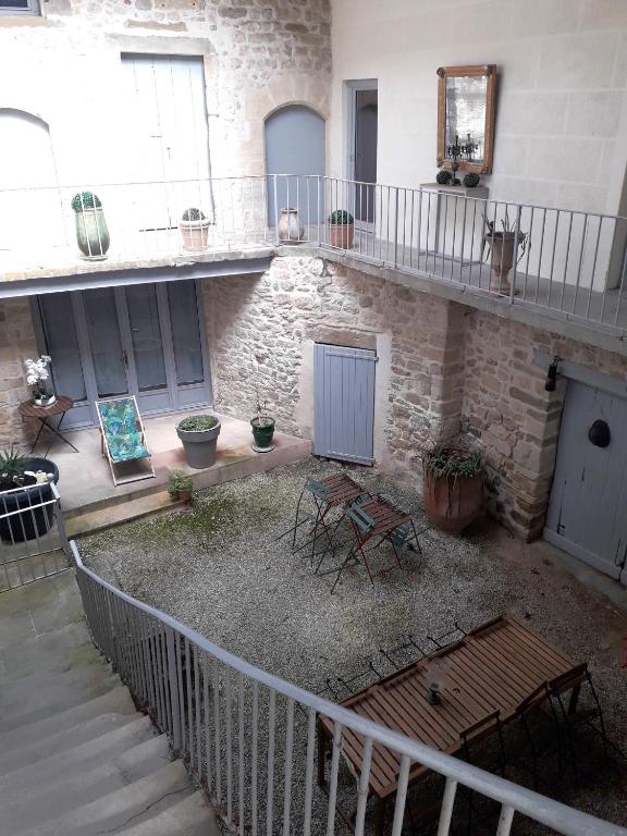 une cour avec des chaises et des tables dans un bâtiment dans l'établissement La maison de Famille d'Uzès, à Aubussargues