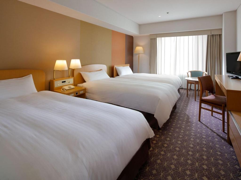 Postel nebo postele na pokoji v ubytování Miyako Hotel Kyoto Hachijo