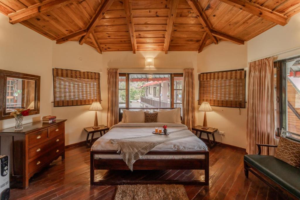 a bedroom with a large bed and wooden ceilings at SaffronStays Casa Octavia in Bhīm Tāl