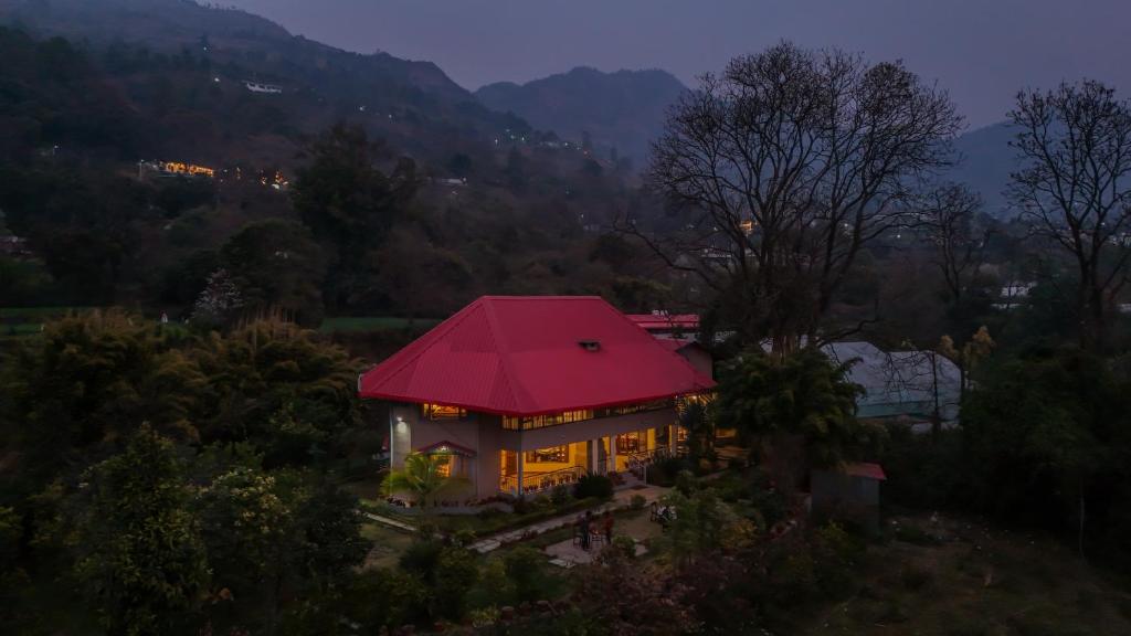 a house with a red roof with lights on at SaffronStays Casa Octavia in Bhīm Tāl