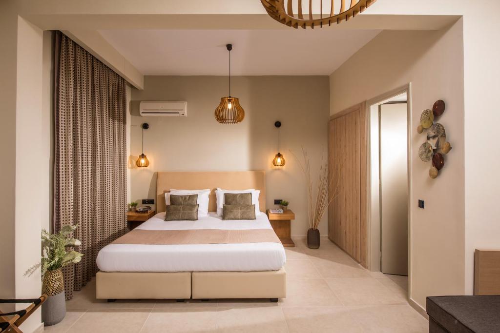a bedroom with a large bed in a room at Malena Hotel & Suites - Adults Only by Omilos Hotels in Amoudara Herakliou