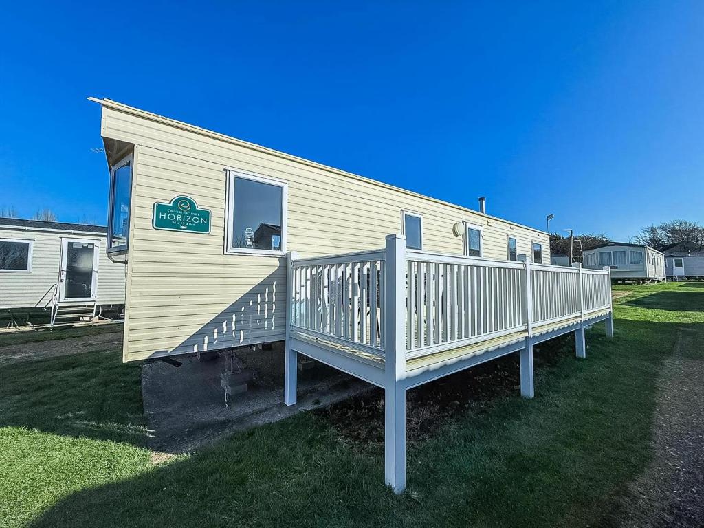 a mobile home with a deck on the grass at 6 Berth Caravan For Hire With Decking At Manor Park In Norfolk Ref 23017S in Hunstanton