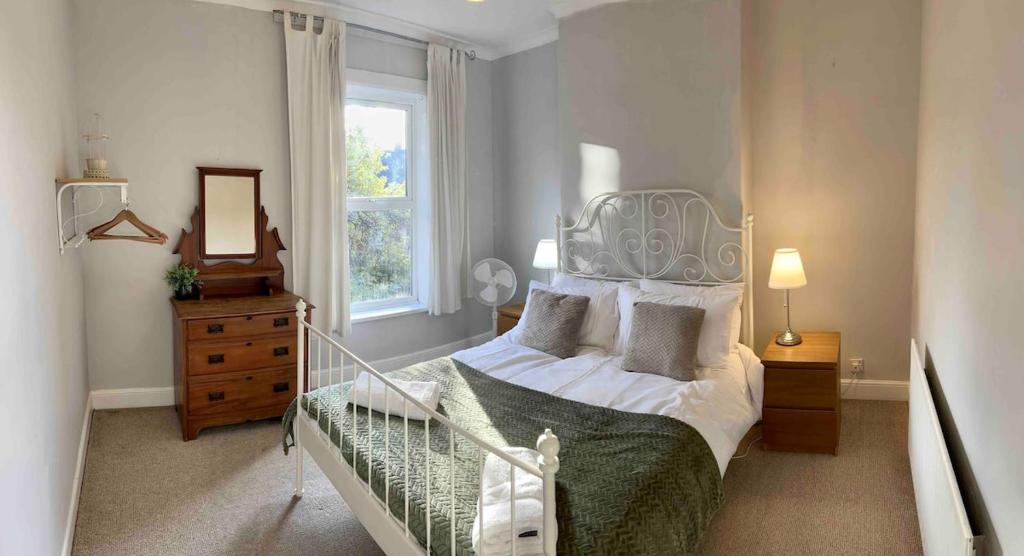 リンカーンにあるCharming Victorian terrace, near Lincoln Castleのベッドと鏡と窓のある寝室