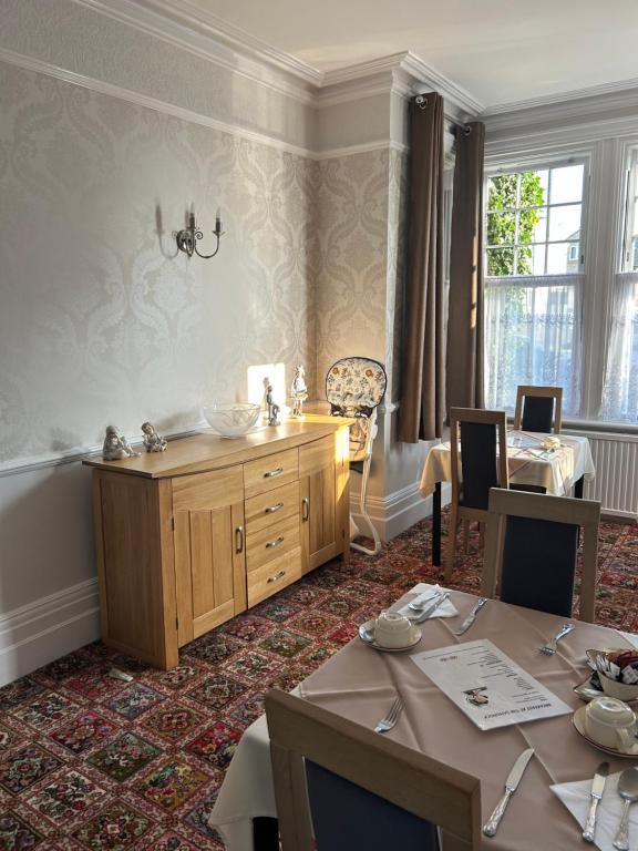 a dining room with a table and a cabinet at The Sandrock in Clacton-on-Sea