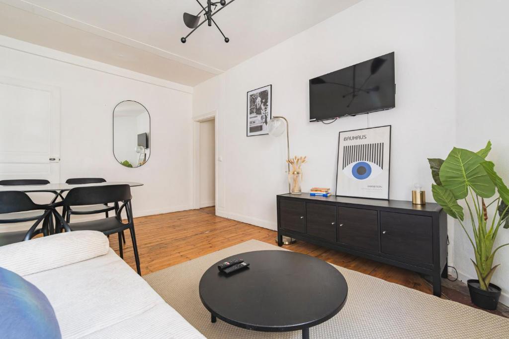 un salon avec un canapé et une table dans l'établissement Le Jaurès - moderne 2 chambres - hyper centre, à Reims