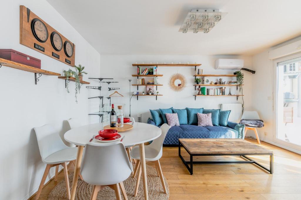 un salon avec un canapé bleu et une table dans l'établissement Transports, parking, A/C & equipped for long stays, à Saint-Ouen