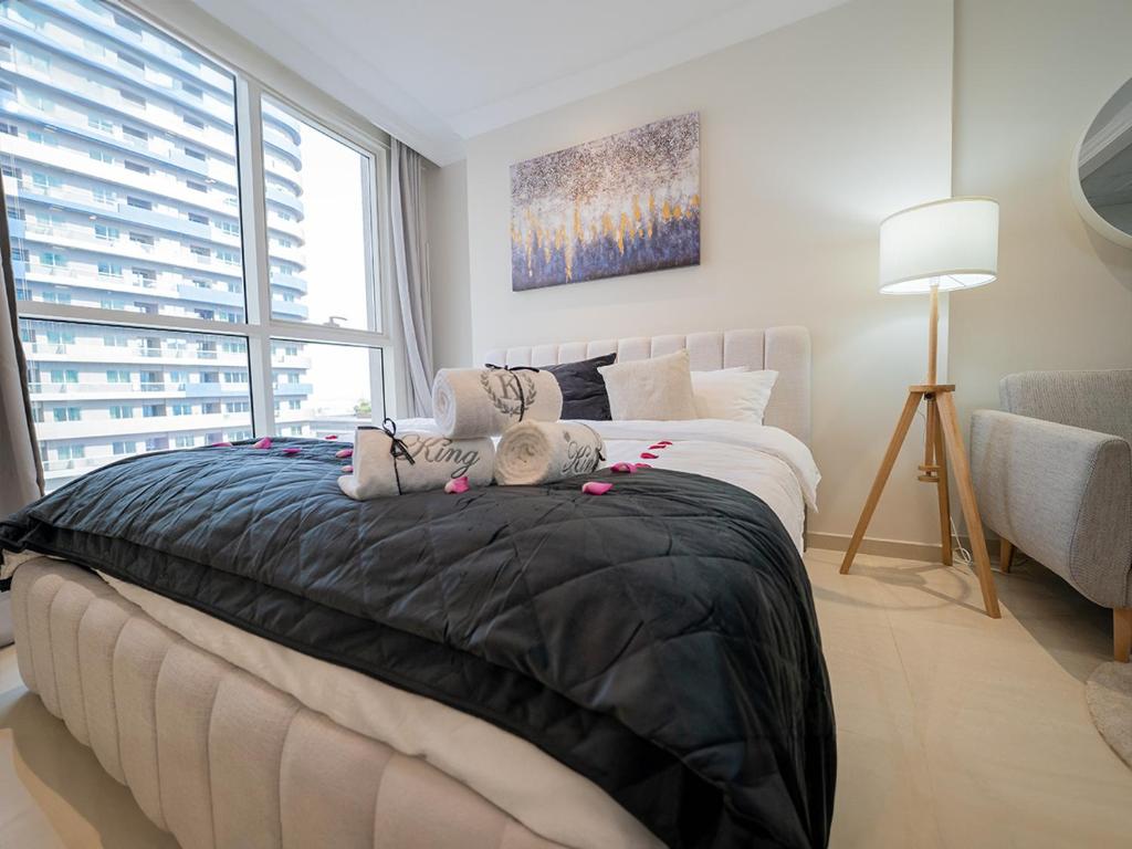 a bedroom with a large bed with a black blanket at Dunya tower suite 2 in Dubai