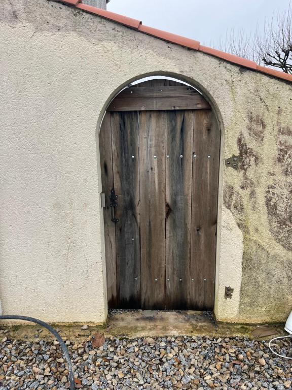 une porte en bois sur le côté du bâtiment dans l'établissement Studio, à Commequiers
