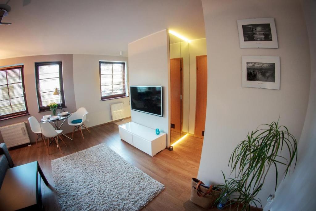 a living room with a flat screen tv and a table at Apartament Karlikowska in Sopot
