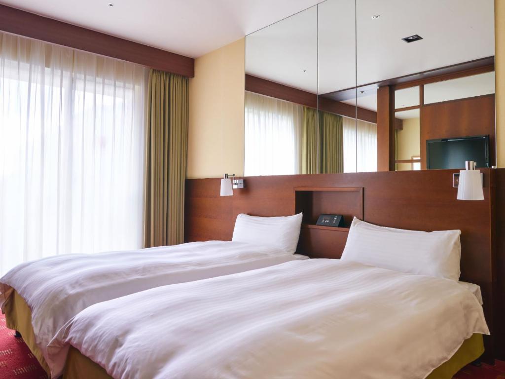 Postel nebo postele na pokoji v ubytování Miyako Hotel Kyoto Hachijo