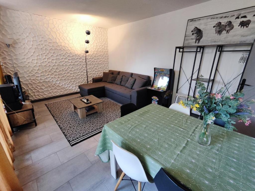 un salon avec une table et un canapé dans l'établissement Apt 9 personnes garage, Wi-Fi, tram, parking, climatisation, jeux, à Avignon