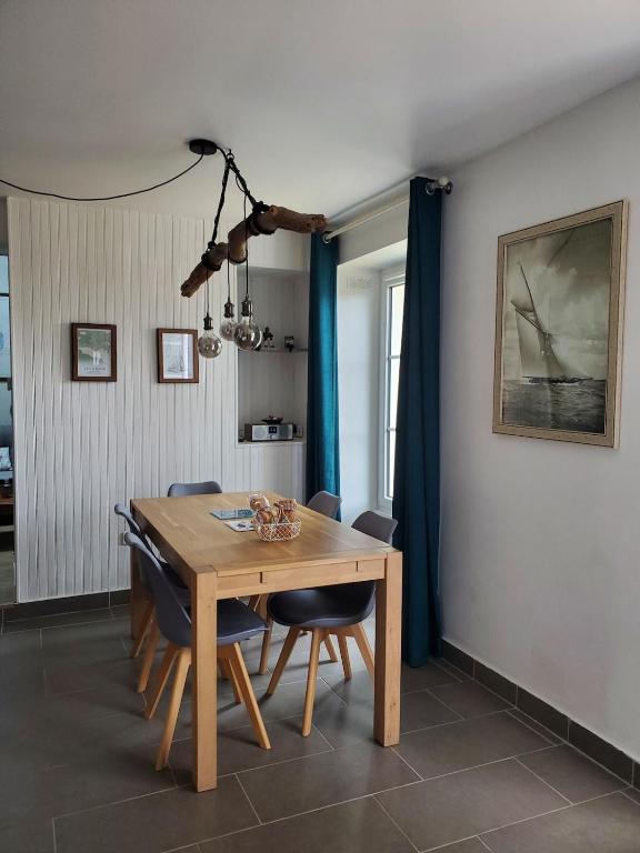 une salle à manger avec une table et des chaises en bois dans l'établissement Appartement duplex sur terrasse - 62m2, à Batz-sur-Mer