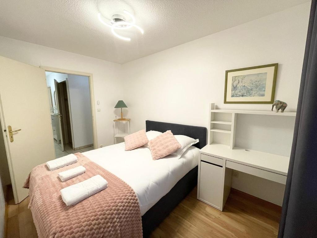 - une chambre avec un lit et un bureau avec des serviettes dans l'établissement Magnifique appartement Fleur, à Saint-Louis