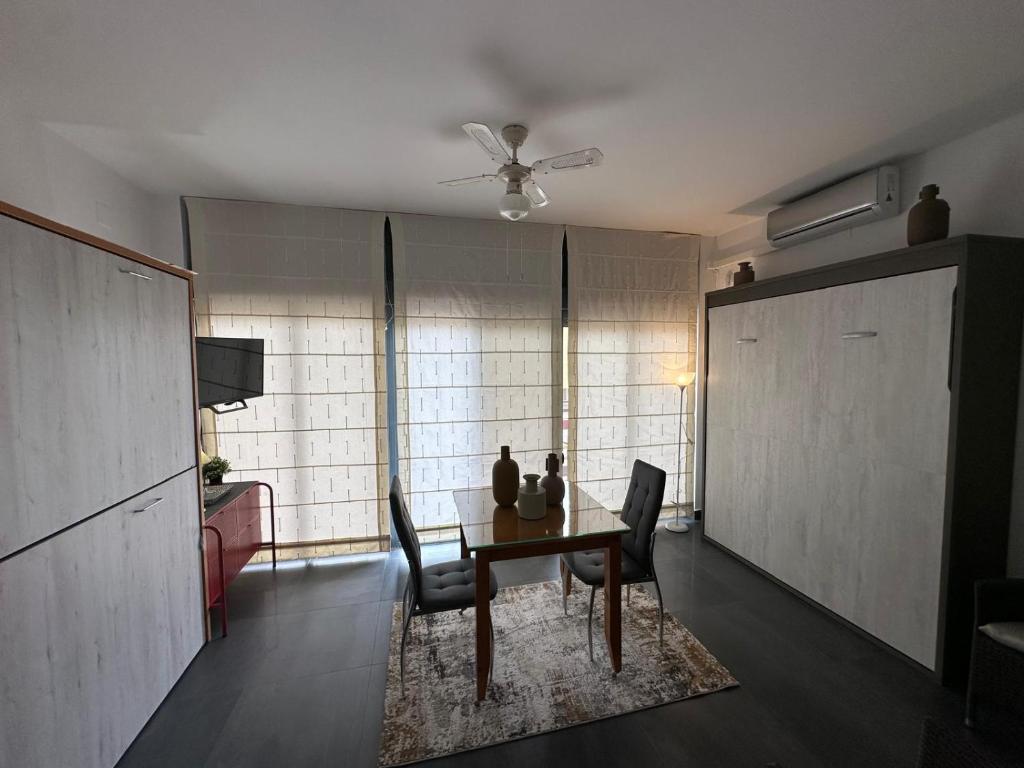 salon ze stołem jadalnym i krzesłami w obiekcie ESTUDIO CON PISCINA Y GARAJE A 100 Mtr DE LA PLAYA w mieście Isla Cristina