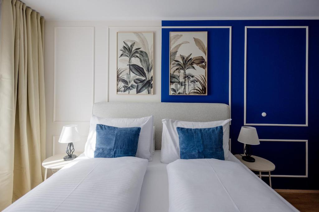 慕尼黑Lumen Homes - Altstadt-Residenz, direkt im Zentrum, geräumiges Apartment mit 5 Zimmern, Küche的一间卧室设有两张带蓝色和白色墙壁的床。