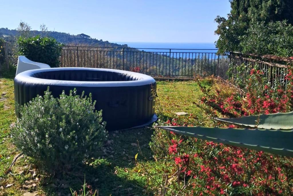 eine große schwarze Badewanne in einem Garten mit einem Zaun in der Unterkunft Elegante villa panoramica con giardino e idromassaggio a 10 minuti dal mare in Castellabate