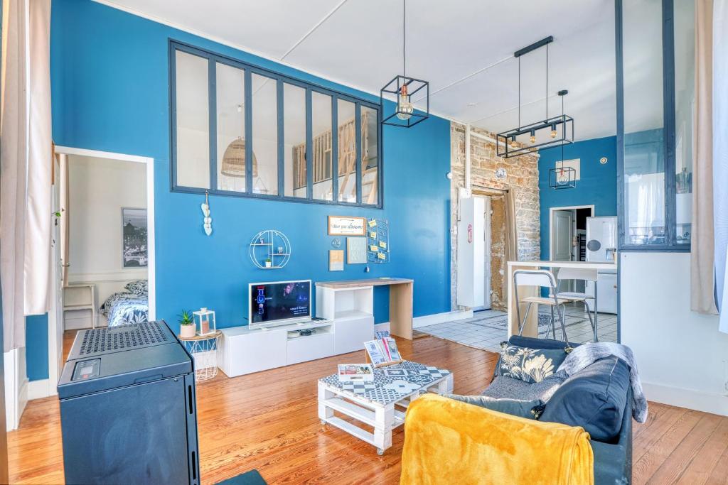 un salon avec un mur bleu dans l'établissement Chaleureux T2 Lyon proche gare, à Lyon