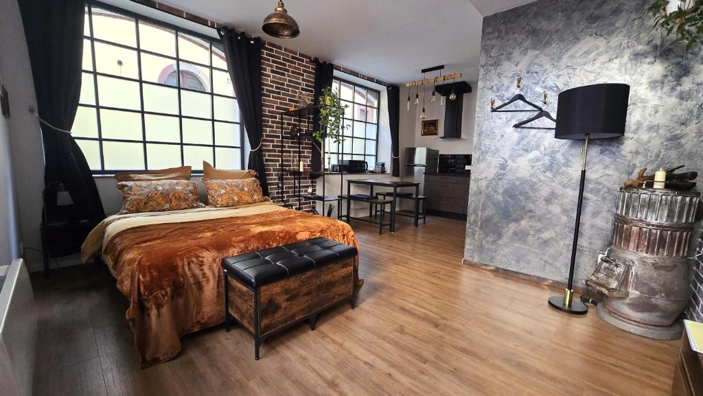 a bedroom with a bed and a brick wall at L'Atelier de l'Arc in Saverne