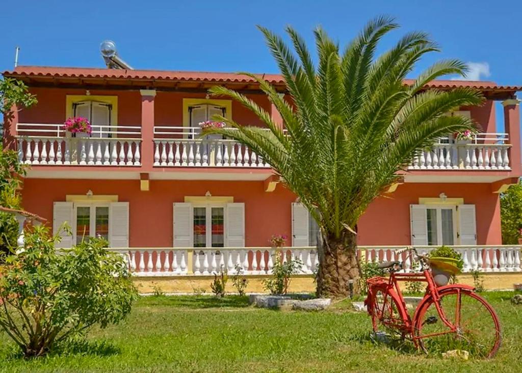 una bicicleta roja estacionada frente a una casa en Condesa Apartments, en Sidari