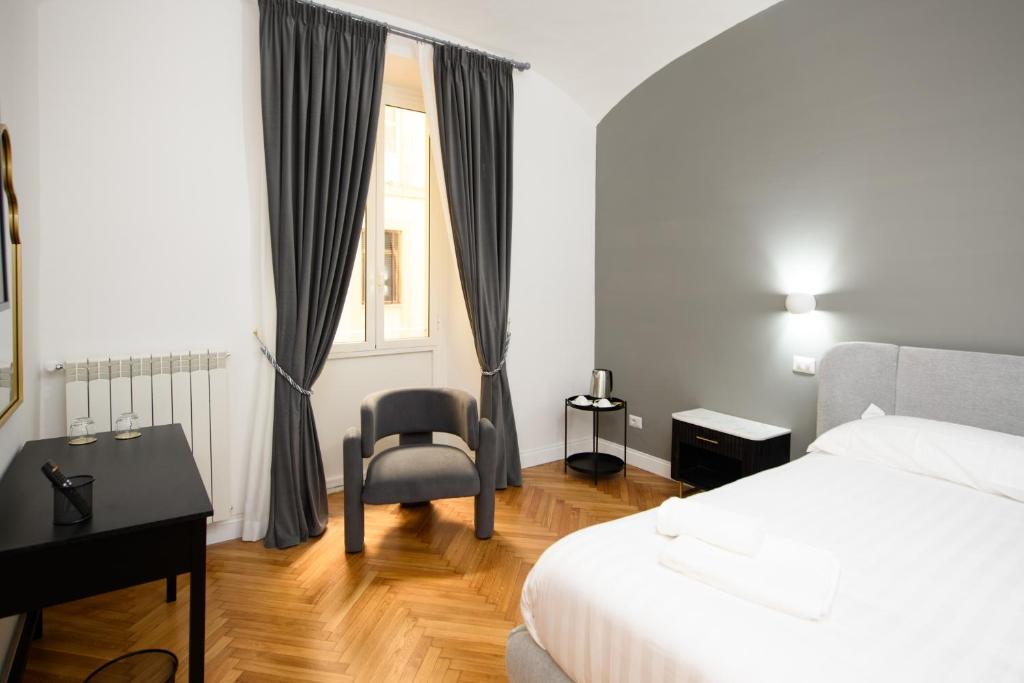 a bedroom with a bed and a desk and a chair at Boncompagni Serenity Suites in Rome