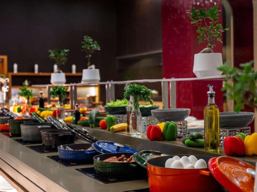 a buffet line with plates and bowls of food at Novotel Fujairah in Fujairah