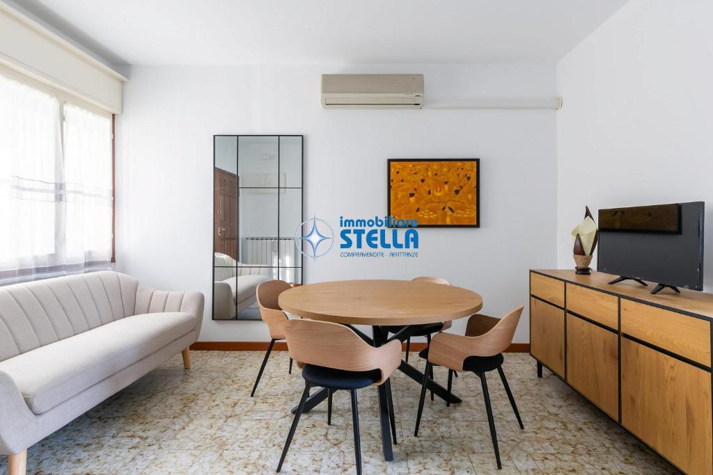 a living room with a table and chairs and a couch at Casa Rialto in Lido di Jesolo