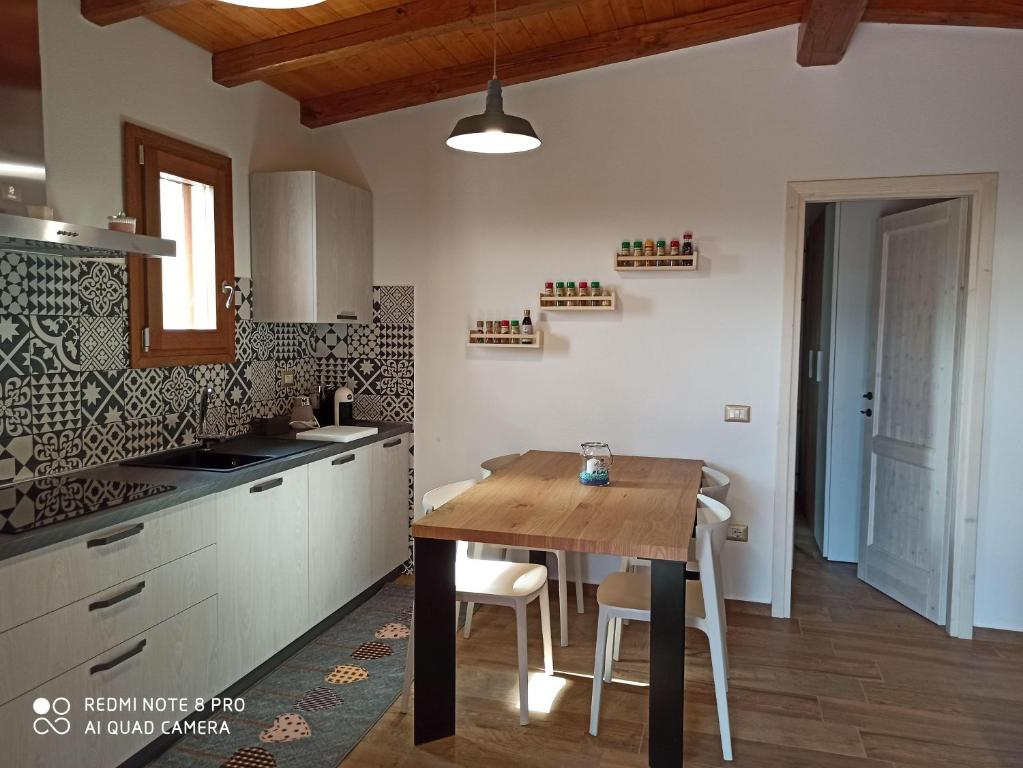 kuchnia z drewnianym stołem i jadalnią w obiekcie Holiday-House-Smeralda w mieście La Caletta