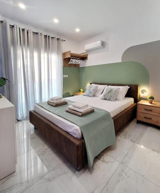 a bedroom with a large bed with a green wall at Coastal Ierapetra 1 in Ierapetra