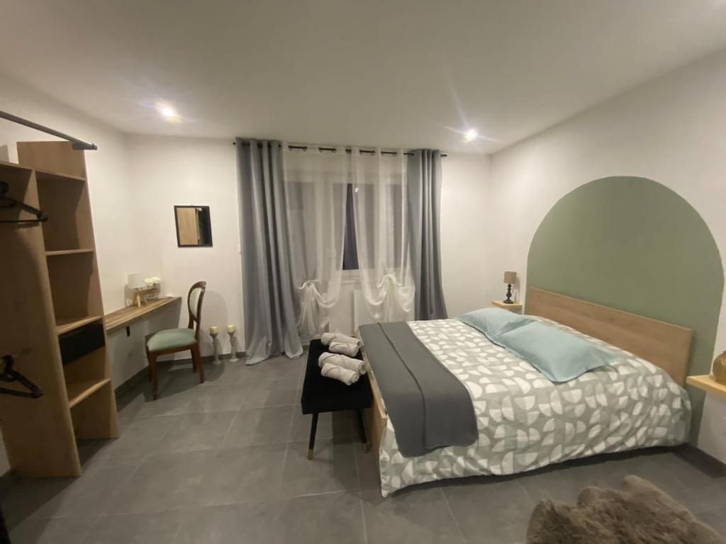 a bedroom with a bed and a desk and a window at Place du bonheur bel appartement f2 in Sarrebourg