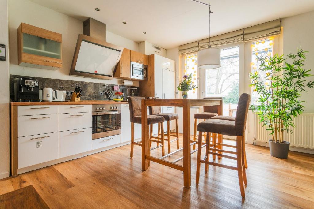una cucina con tavolo e sedie in legno di Apartment Hannover Top Citylage ad Hannover