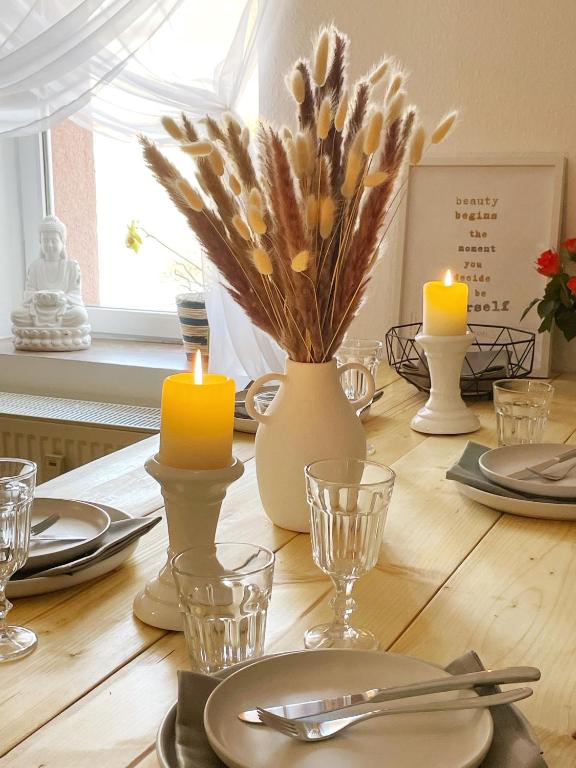 a dining room table with candles and plates and glasses at "Ferienwohnung Naturliebe - grünes Paradies im Zentrum in Luckenwalde