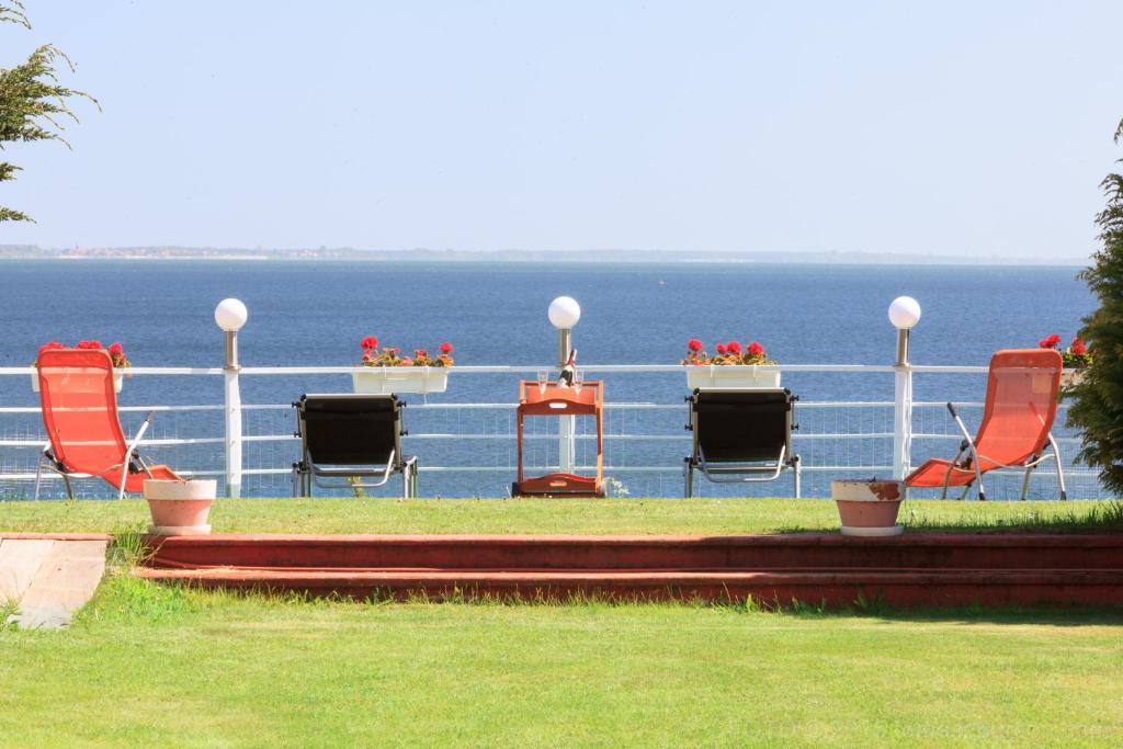 um grupo de cadeiras sentadas no topo do oceano em Eugen Apartments em Swarzewo