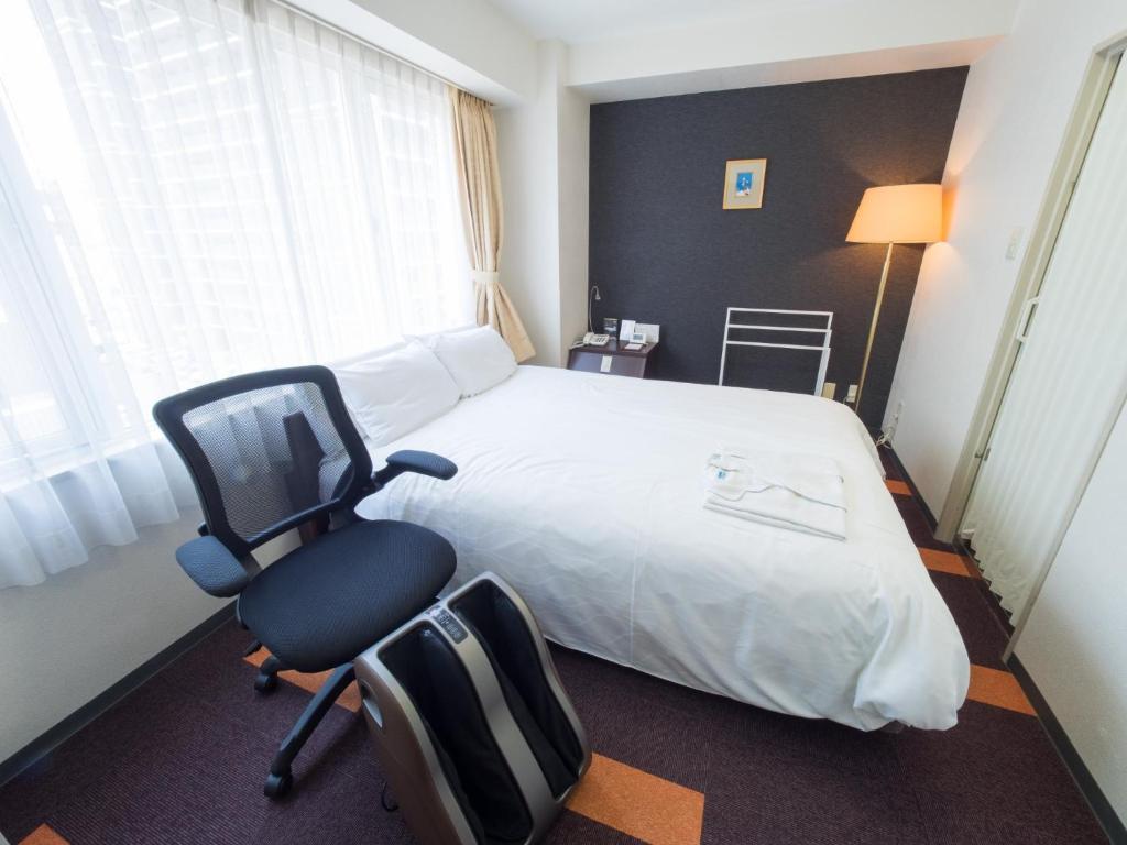a hotel room with a bed and a desk and a chair at Hotel Shin Osaka / Vacation STAY 81537 in Osaka